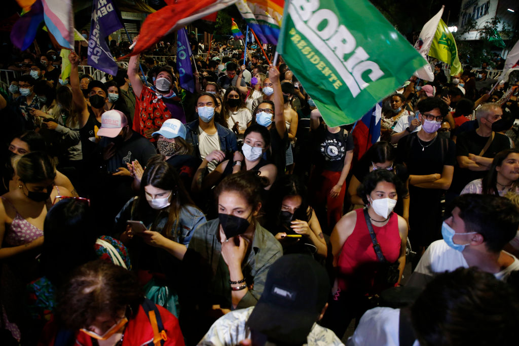 SANTIAGO, CHILE - NOVEMBER 21: Supporters of candidate for Convergencia Social Gabriel Boric wave flags at the end of the Presidential Elections on November 21, 2021 in Santiago, Chile. According to official results, candidate of the Republic party Jose Antonio Kast has 28% of the votes and Boric 25,6%, with 90,19 of the voting counted. Kast and Boric will compete in the presidential runoff on December 19, 2021(Photo by Marcelo Hernandez/Getty Images)