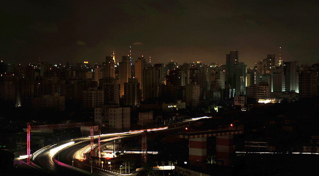 Residential buildings in the Moema neighborhood stand in darkness, the city lit solely by antennas atop buildings and vehicles headlights, during a massive blackout in Sao Paulo, Brazil, early November 11, 2009. A massive blackout across the southern half of Brazil has plunged tens of millions of people into darkness and prompted a major police mobilization amid fears of an opportunistic crime wave. AFP PHOTO/Mauricio LIMA