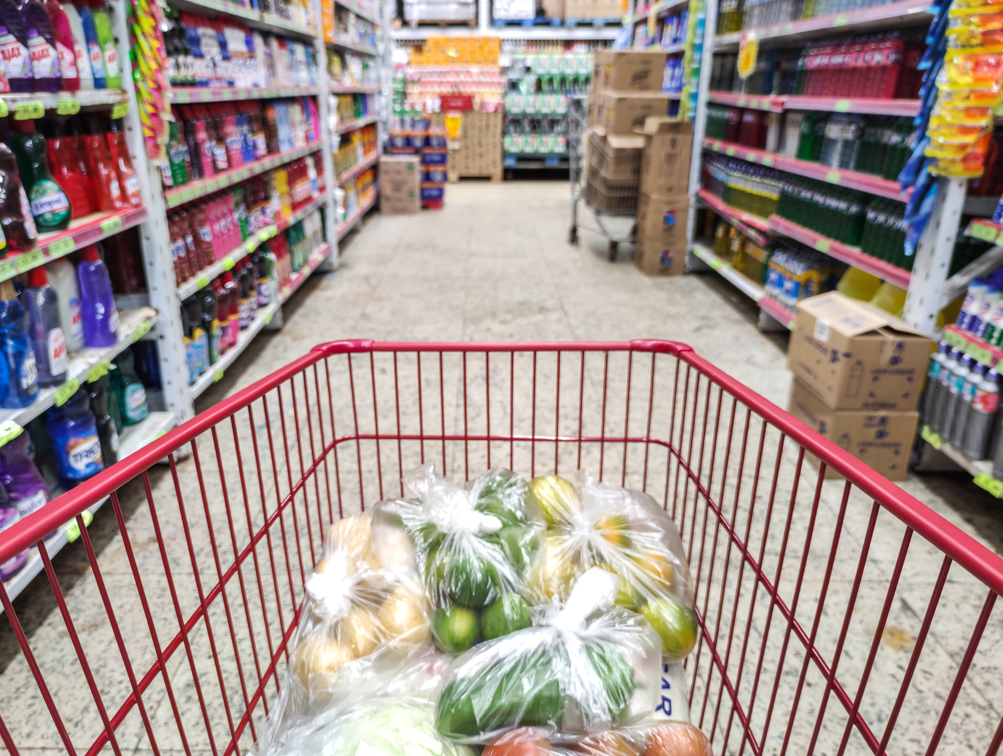 Supermarket aisle with empty shopping cart business concept.