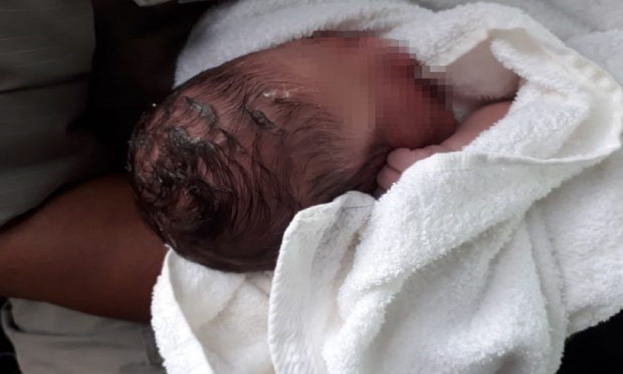 O bebê chorava muito quando foi encontrado e ainda estava com o cordão umbilical| Foto: Reprodução/ Corpo de Bombeiros