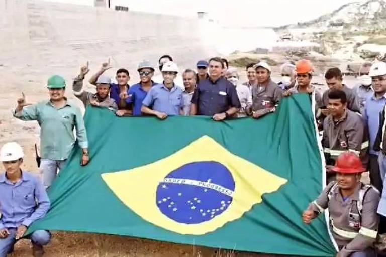 Imagem Ilustrando a Notícia: Em foto com Bolsonaro, trabalhadores fazem sinal de ‘L’ associado a Lula