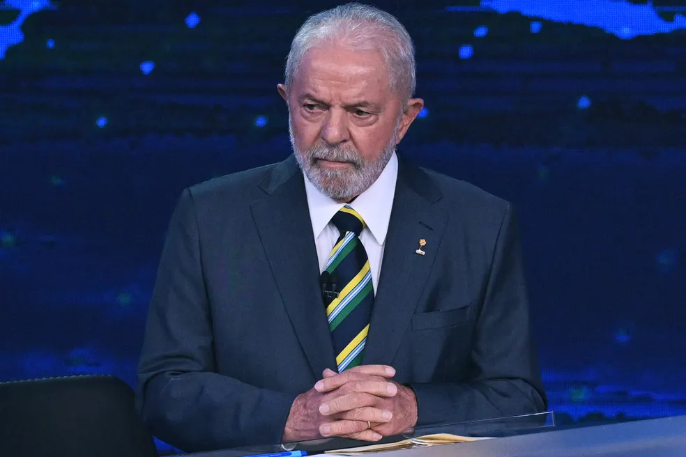 Imagem Ilustrando a Notícia: Lula usa broche de campanha de combate à violência sexual, em debate presidencial