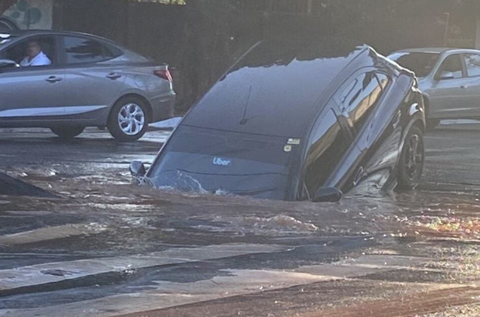 Imagem Ilustrando a Notícia: Carro cai em cratera após adutora de água se romper na Avenida Independência, em Goiânia