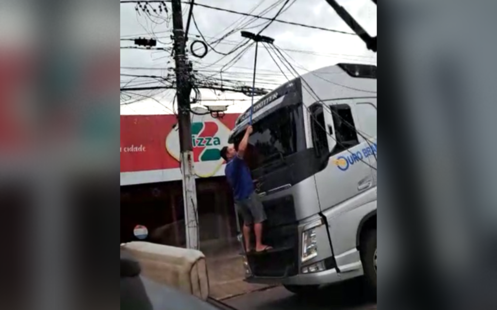 Imagem Ilustrando a Notícia: Homem usa vassoura para retirar fios arrebentados por cima de caminhão em Goiânia; veja o vídeo