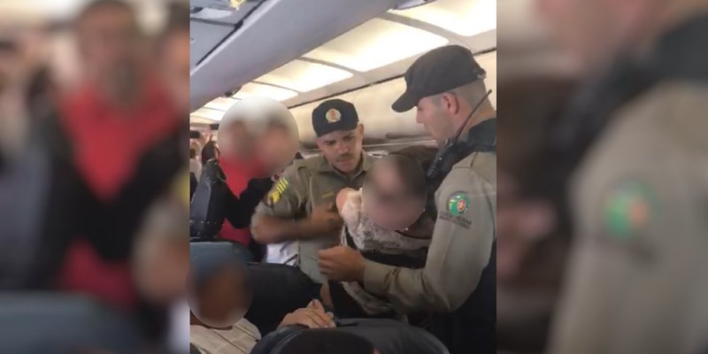 Imagem Ilustrando a Notícia: Mulher é retirada à força por policial de dentro de avião
