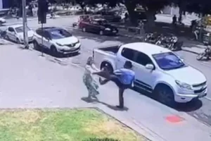 O caso ocorreu em frente a um shopping em João Pinheiro, Minas Gerais; o agressor, Sócrates Porto, segurava o filho do casal no colo quando atacou a ex-companheira. | Imagem: Reprodução