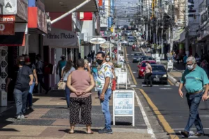 Marilia, Sao Paulo, Brazil, July 27, 2020: Movement of consumers and vehicles on Sao Luiz street, one of the main commercial streets in Marilia, during the limited opening of commercial establishments. in the prevention of Covid-19, in downtown of Marilia, in the central-west region of Sao Paulo