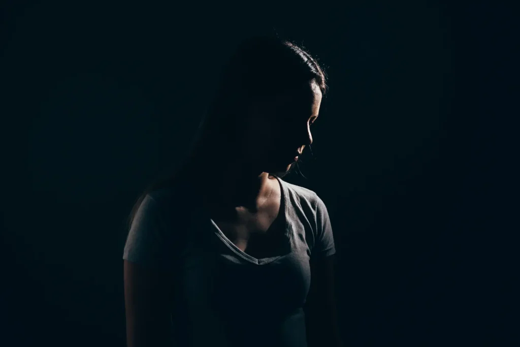 Sad woman in dark room. Depression and anxiety disorder concept