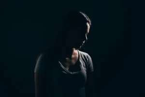 Sad woman in dark room. Depression and anxiety disorder concept