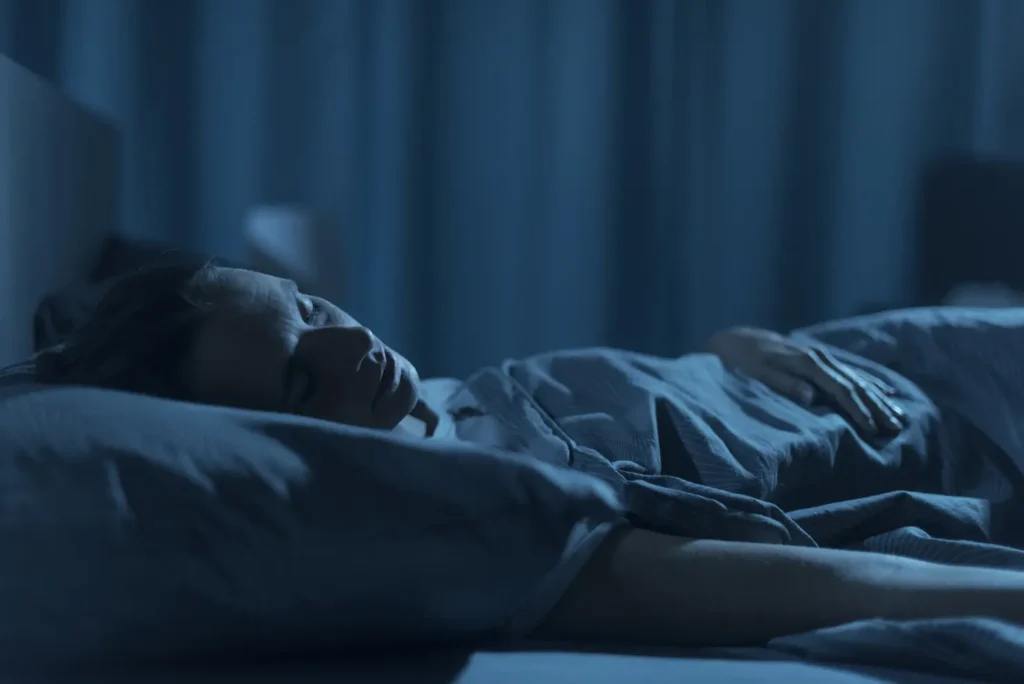 Woman sleeping in her bed at night, healthy lifestyle concept