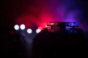 Police cars at night. Police car chasing a car at night with fog background. 911 Emergency response police car speeding to scene of crime. Selective focus