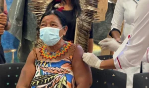 Senhora ndigéna recebendo a dose da vacina contra a covid-19