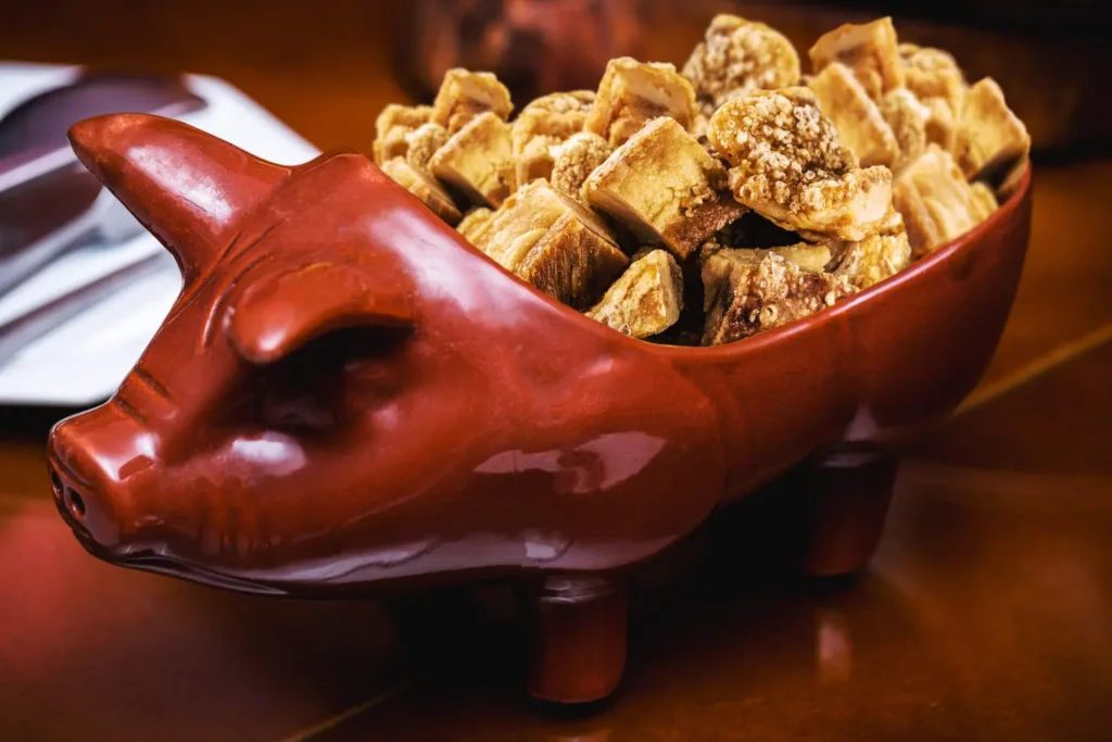 Torresmo, pururuca or crackling pork, brazilian pork meat, fried, served in a bowl in the shape of an handmade pig, typical food of brazil from the state in minas gerais