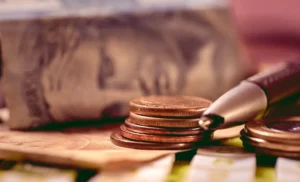 Real currency, Brazil money. Brazilian Real banknotes and coins on top of a calculator and a broken pen in the composition. Macro photography. Concept of Brazilian economy, debts and inflation.