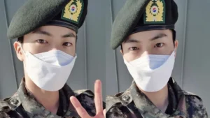 A foto de Jin que está no celular da garota mostra ele trajado de militar, utilizando o uniforme do exército sul-coreano | Foto: Reprodução/Weverse