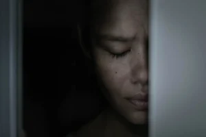 A scaared woman depressed hiding in the closet ashamed and frightened.