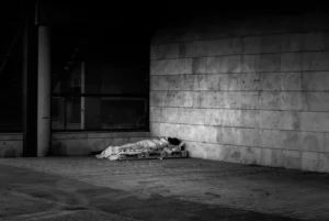 Person sleeping on the street, homeless vagrant, social poverty
