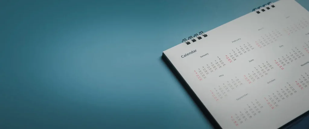 Embroidered red pins on a calendar event Planner calendar,clock to set timetable organize schedule,planning for business meeting or travel planning concept.
