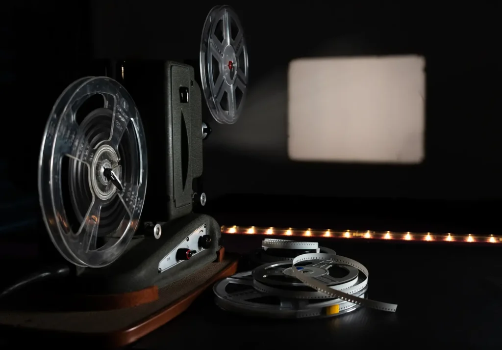 Vintage 8mm film projector with blank frame and reels.