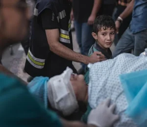 Criança assustada vendo a mãe entrar no hospital depois de ter sido ferida por um ataque aéreo israelense | Foto: Motaz Azaiza