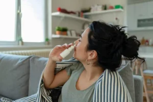 Treatment for Allergies or Common Cold. Woman Using Nasal Spray Drops of Medicine in Her Nose. Rhinitis, Allergy.