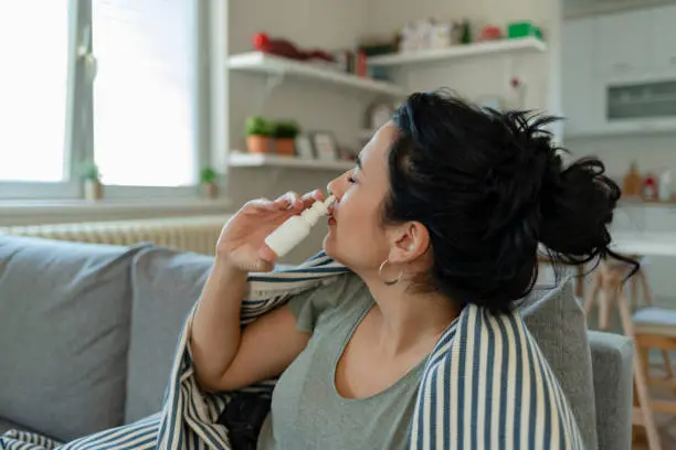 Treatment for Allergies or Common Cold. Woman Using Nasal Spray Drops of Medicine in Her Nose. Rhinitis, Allergy.