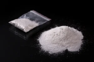 Cocaine in plastic packet on black background, closeup