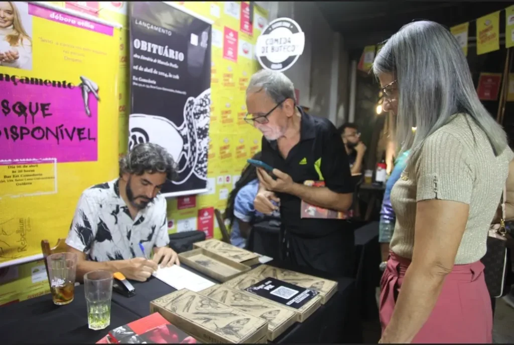 O livro é apresentado em uma caixa gaveta, uma alusão às gavetas 
mortuárias dos cemitérios, refletindo o estilo 'tropical sombrio' que permeia os 
textos. | Foto: Vandimar Marques e Itandheuy Csatañeda