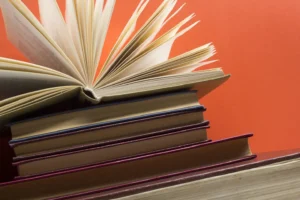 Open book, hardback books on wooden table. Back to school. Copy space.