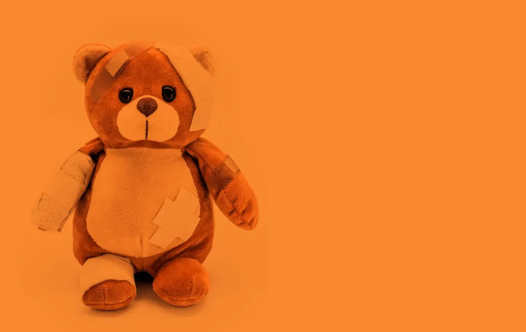 injured teddy bear with orange tone , conceptual image about orange may, month of prevention of child abuse and domestic violence