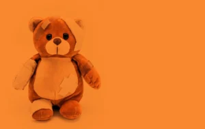 injured teddy bear with orange tone , conceptual image about orange may, month of prevention of child abuse and domestic violence