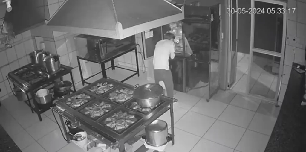 As imagens mostram o suspeito vasculhando a cozinha do restaurante e se servindo de pratos prontos e doces | Foto: Reprodução
