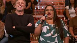 Luciano Huck (esq.) com Patrícia Veloso Martins, a mulher do meme "que Xou da Xuxa é esse?". Globoplay / Reprodução