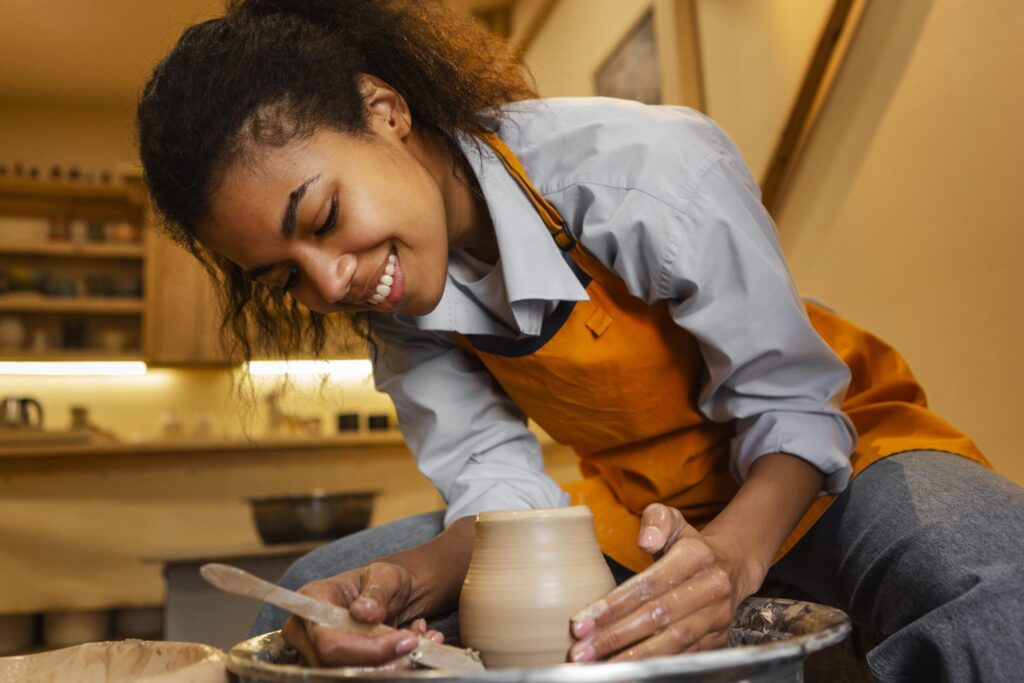 mulher sorridente fazendo ceramica dentro de casa 1 scaled 1