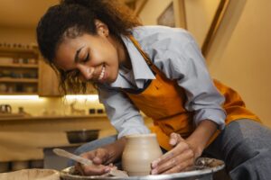 mulher sorridente fazendo ceramica dentro de casa 1 scaled 1