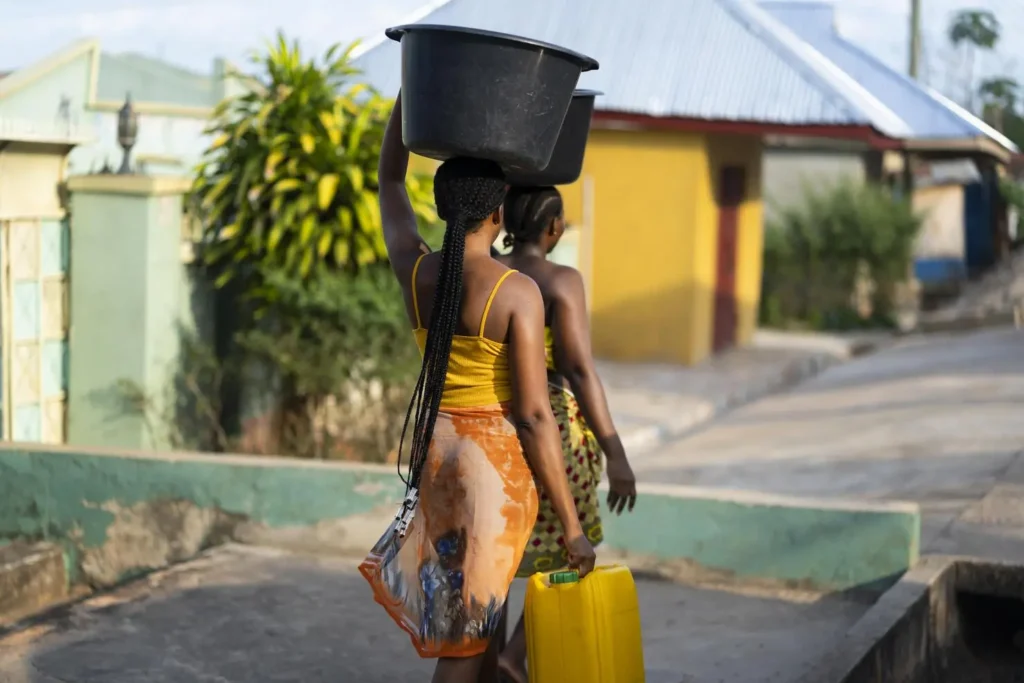 beautiful african women fetching water from outside