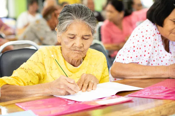 mulher idosa estudando vencendo o analfabetismo