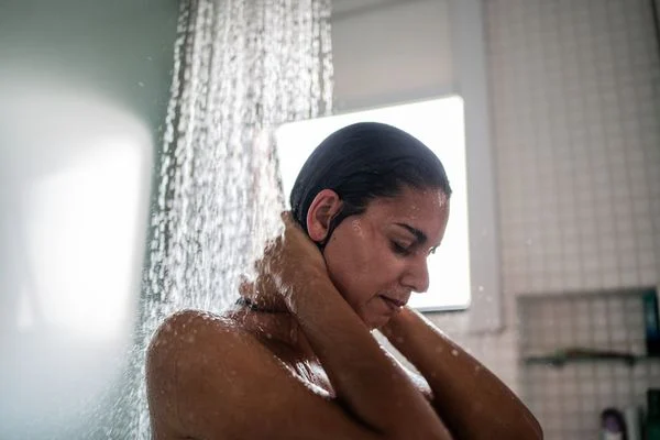 Esse é o melhor banho para relaxar seu corpo 2 mulher tomando um banho de chuveiro card m 1