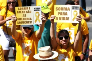 Participantes de caminhada do Setembro Amarelo carregam cartazes com mensagens de conscientização sobre a prevenção do suicídio. (Foto: Tânia Rêgo/Agência Brasil)